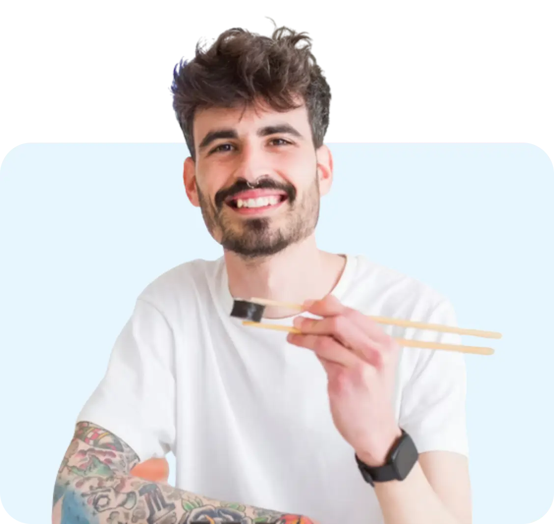 man smiling eating sushi