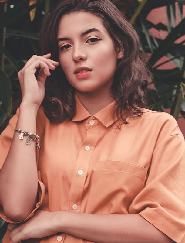 hero image of girl wearing orange polo shirt from Base Apparel