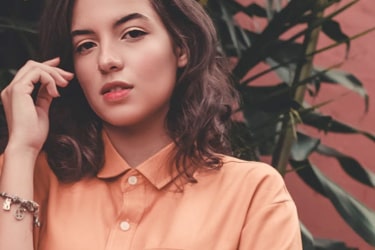 hero image of girl wearing orange polo shirt from Base Apparel